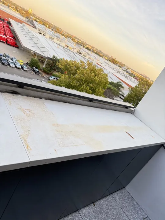 Stained stone capping on a building parapet before the repair