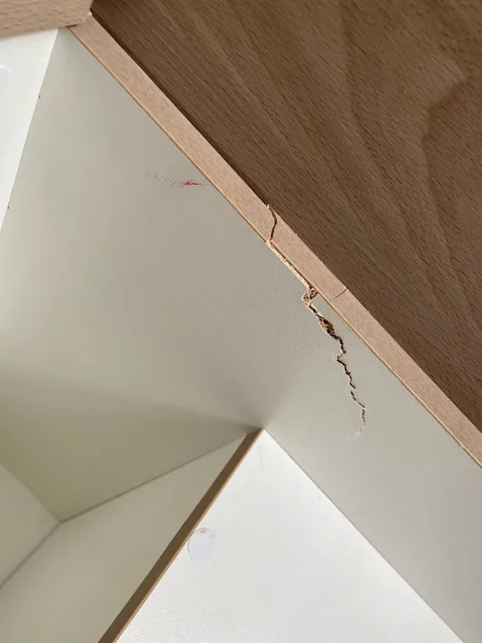 Before: chipped white panel edge inside a cupboard beside timber trim