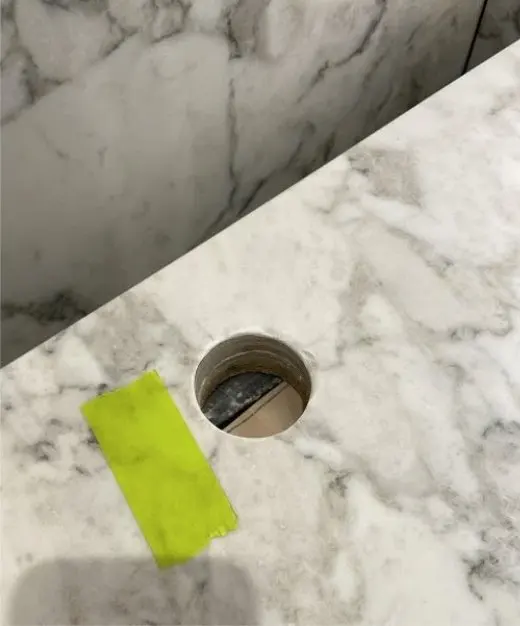 Before — core-drilled tap hole in a marble bench top