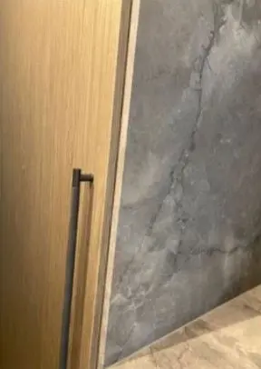 After — chip on the edge of a dark stone wall panel