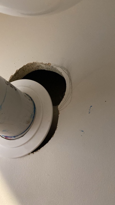 Before — oversized hole cut around a waste pipe