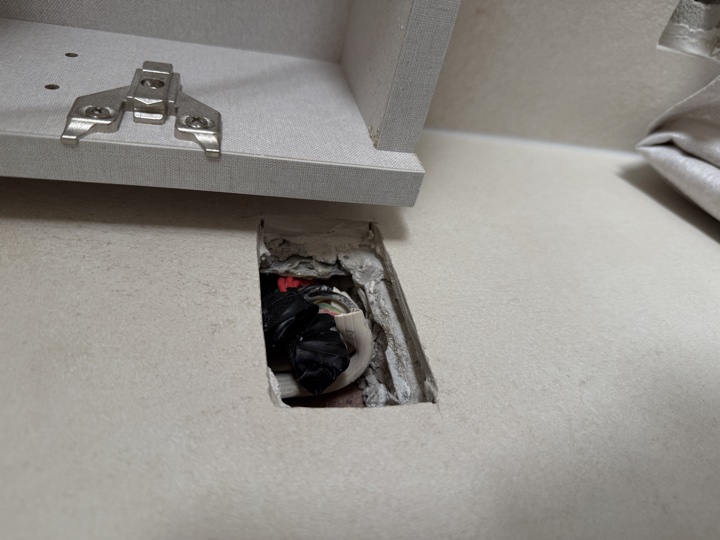 Before — rough cut-out in a wall with cabling exposed